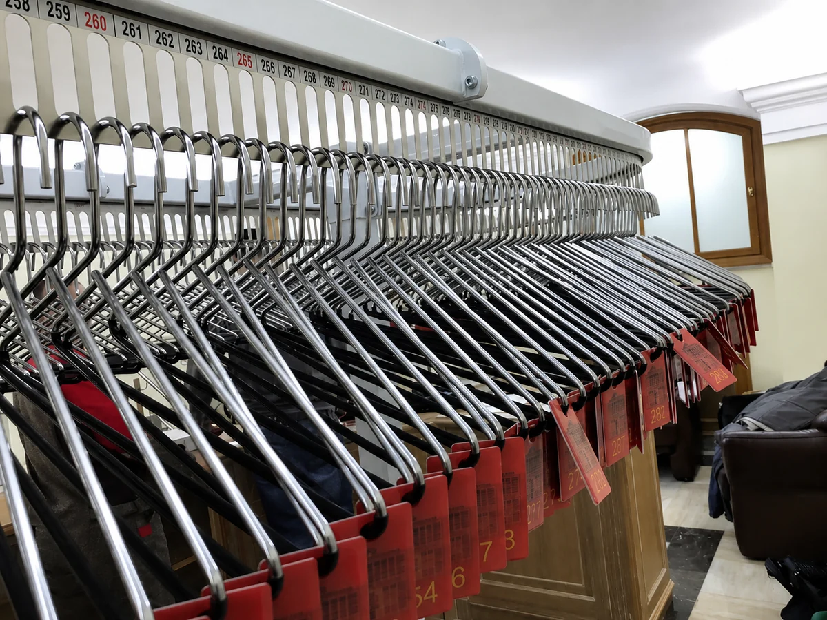 Numbered coat check conveyor positions with matching garment hangers